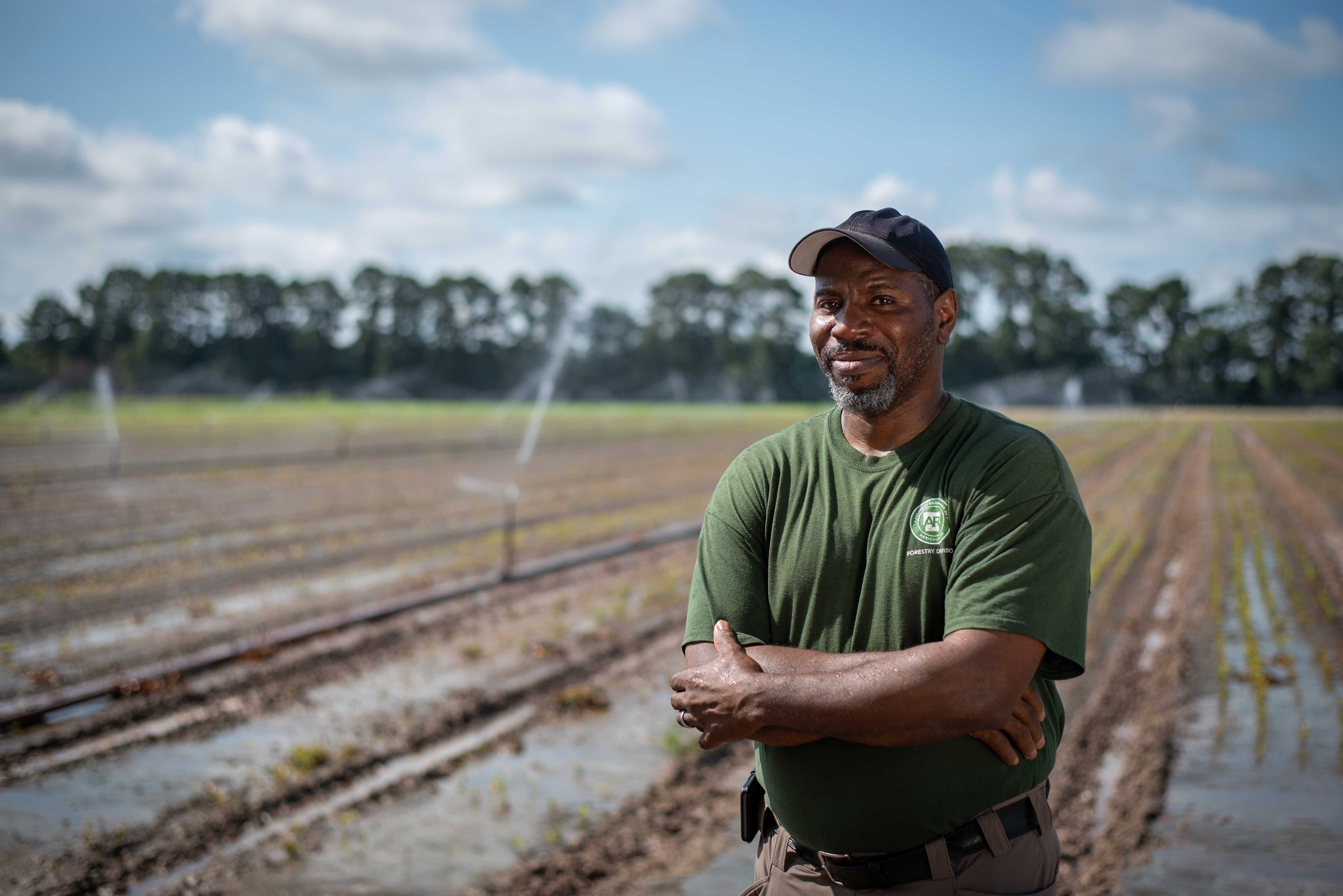 James Shelton stands in front of an agricultural field.