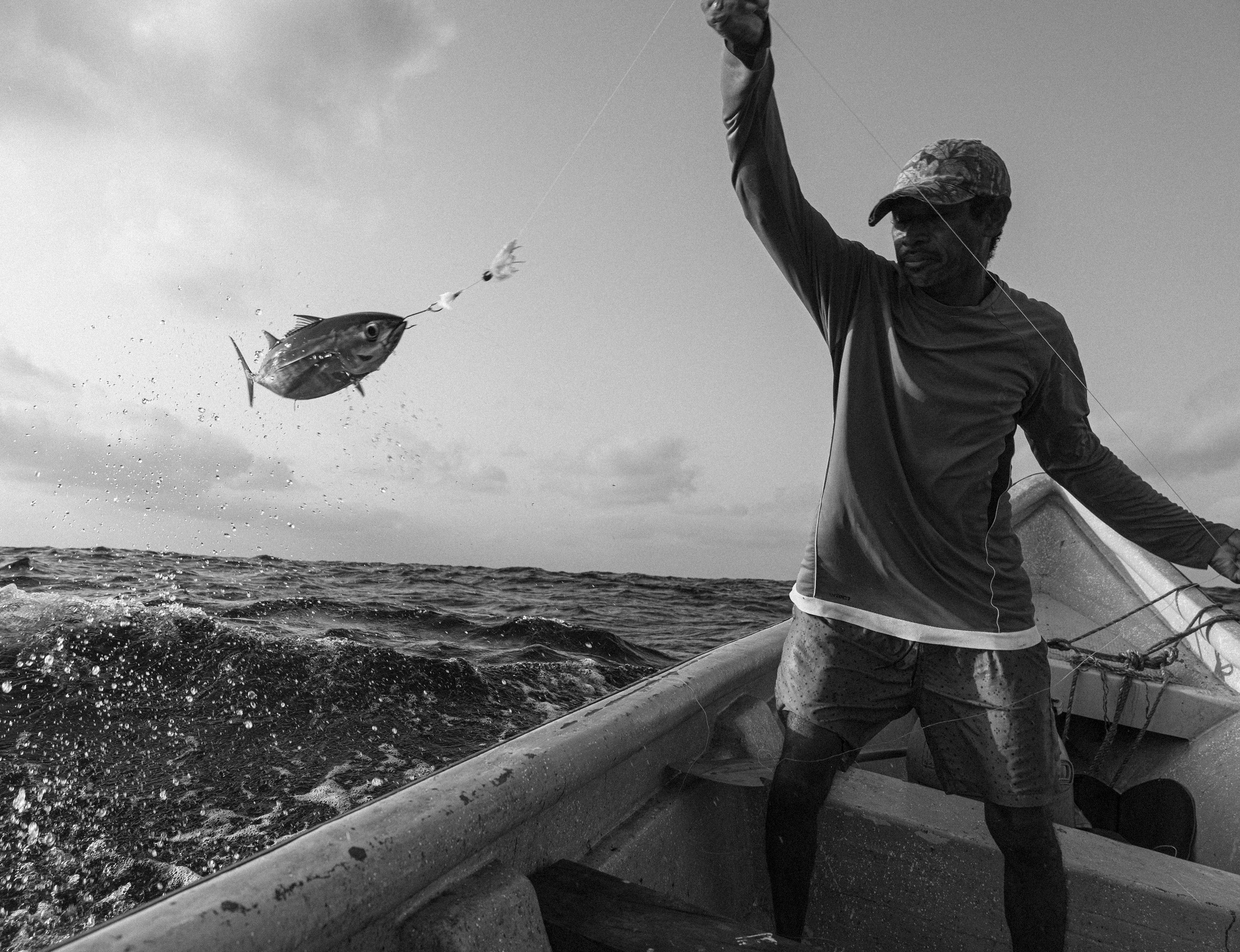 Un pescador colombiano saca un pez del agua.