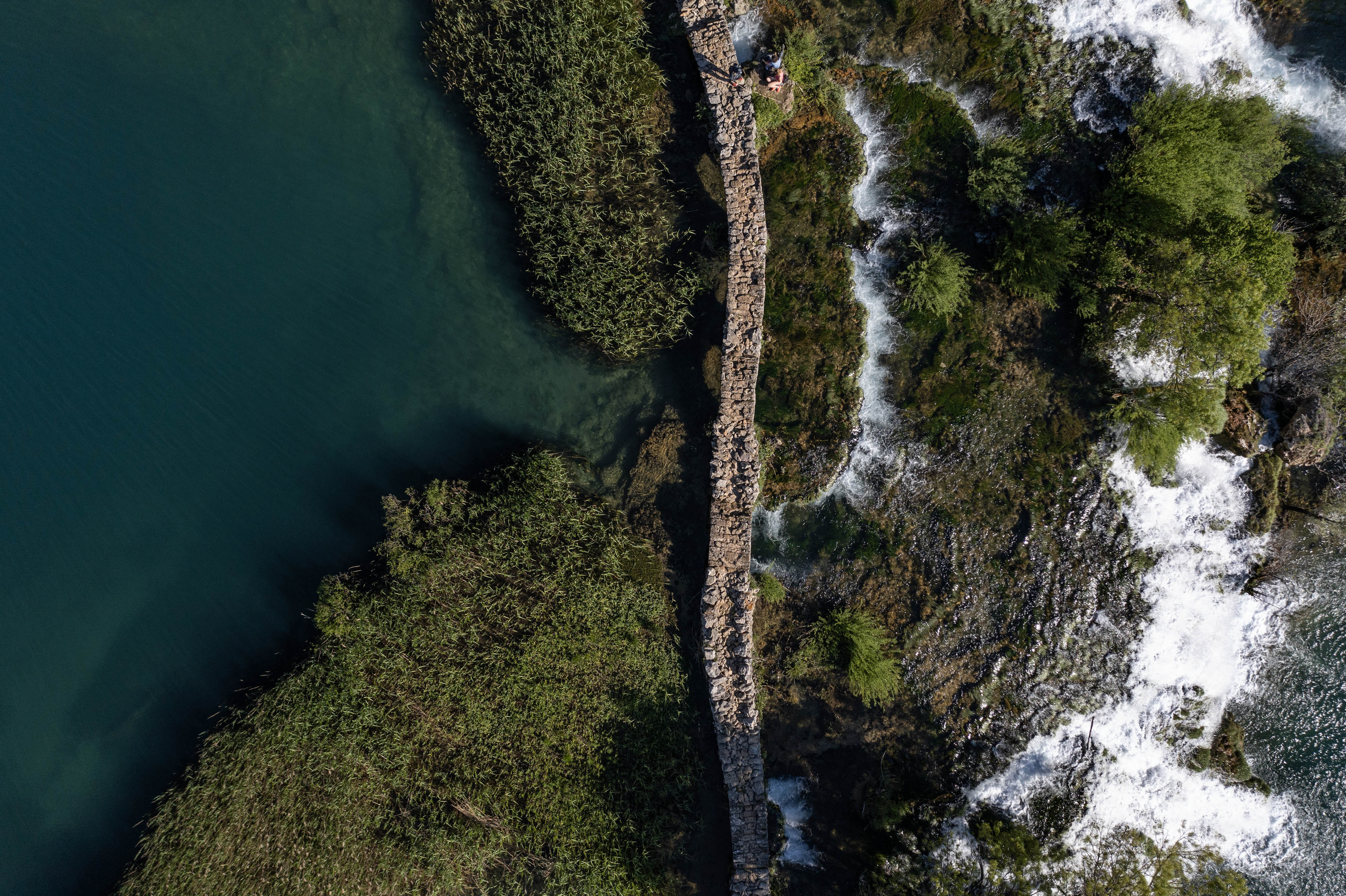 An aerial photo shows a stone bridge over a river.