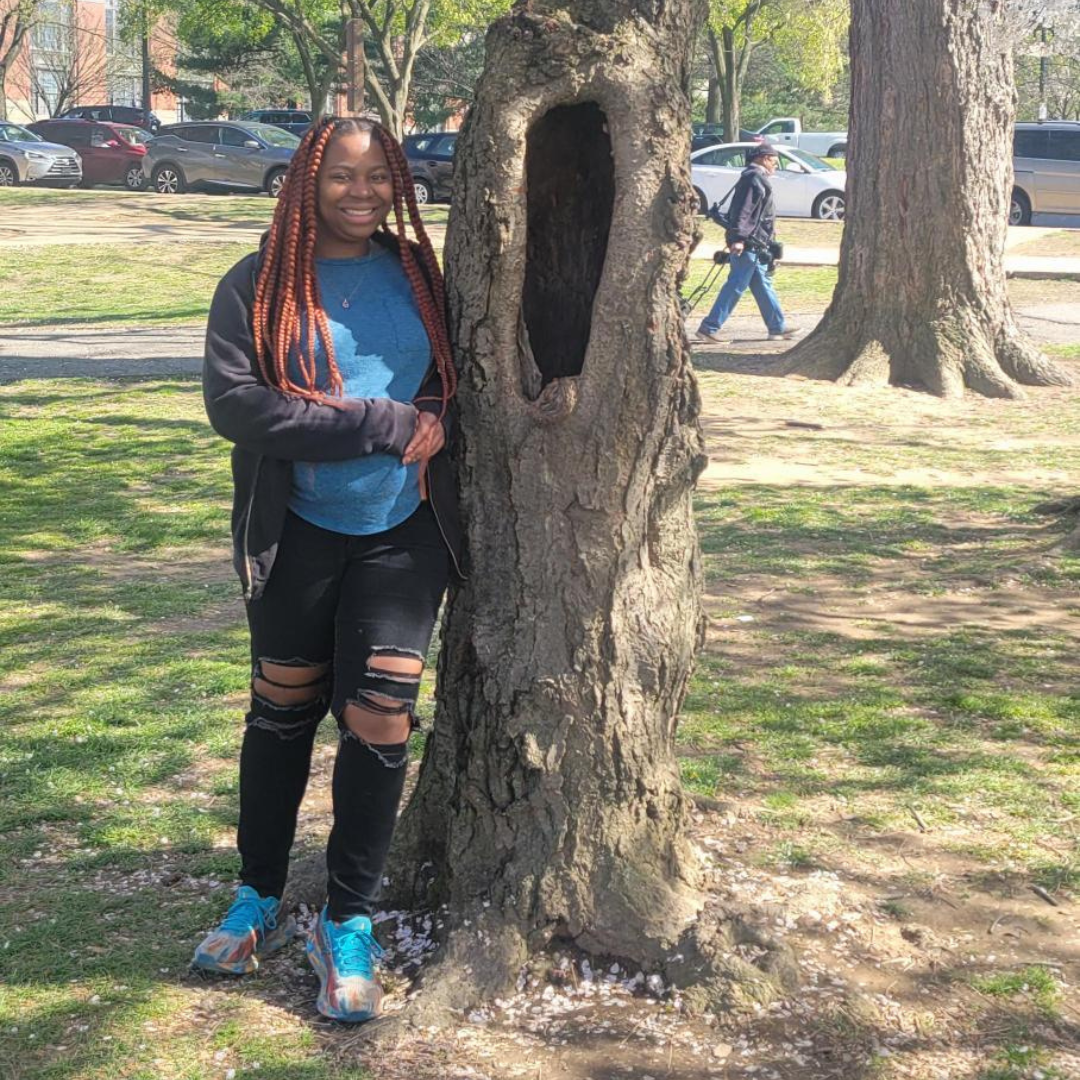 Tonyisha Harris stands by a tree in a park.